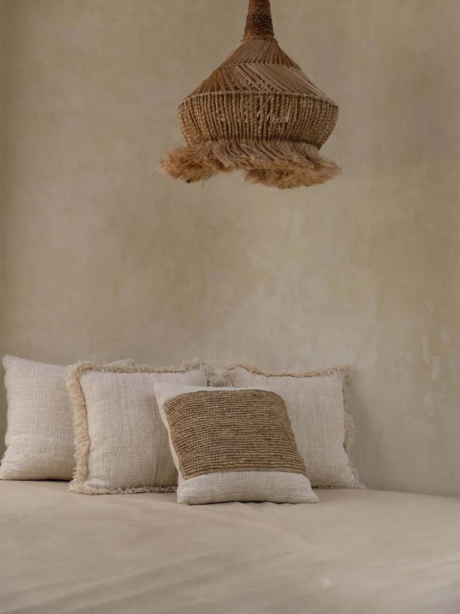 Kissen Babette aus weicher Baumwolle mit Bastdetails.